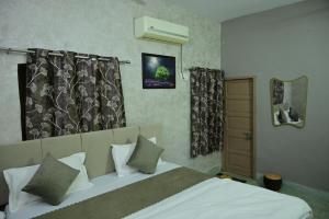 a bedroom with a large bed with white sheets and pillows at The Mapple Stay in Jodhpur
