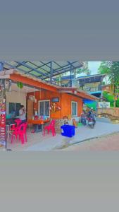 a house with red chairs and a table in front of it at Mook Phoopha Guest House in Koh Mook