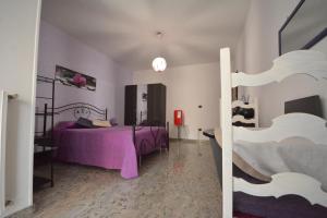 a bedroom with a bed with purple sheets at Ciao Bello B&B in Martina Franca