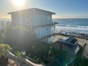 a house on the beach with the ocean behind it at 8 Muller st Tergniet in Tergniet