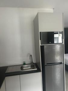 a small kitchen with a refrigerator and a sink at The Spear Guest Lodge in Graskop