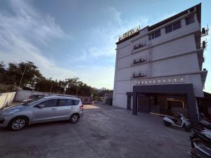ein Auto, das auf einem Parkplatz vor einem Gebäude geparkt ist in der Unterkunft Hotel Kushala Grand, Dombivali in Mangrul