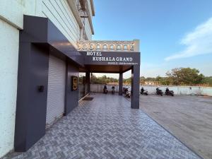 ein Schild an der Seite eines Gebäudes mit geparkten Motorrädern in der Unterkunft Hotel Kushala Grand, Dombivali in Mangrul