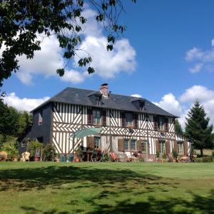 a large house with a black and white at L'Orchard in Bonneville-la-Louvet