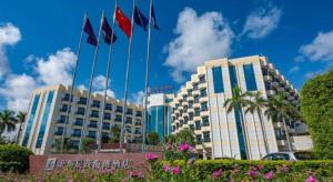 un edificio con delle bandiere davanti di Excemon Beach Hotel Beihai a Beihai