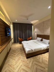 a hotel room with a bed and a television at Hotel Nirmal's Executive in Pune +27 photos