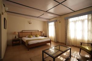 a bedroom with a bed and a coffee table at Ri Sai Cottage Stays in Nongpoh