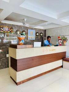 a man sitting at a counter in a restaurant at Hotel Nirmal's Executive in Pune