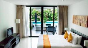 een slaapkamer met een bed en uitzicht op een zwembad bij Sansuri Resort in Surin Beach