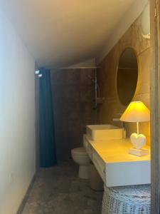 a bathroom with a sink and a toilet and a lamp at Casetta Teppe rosse in Aléria