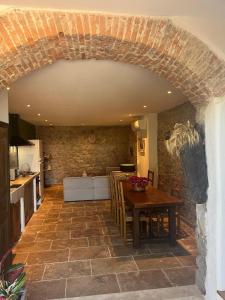 a kitchen and dining room with a table and a stone wall at Casetta Teppe rosse in Aléria +6 photos