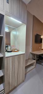 una cucina con armadi in legno, tavolo e TV di Sunflower Hotel Syariah near Juanda Airport a Dares