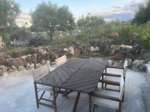 a wooden table and two chairs sitting next to a garden at Casetta Teppe rosse in Aléria
