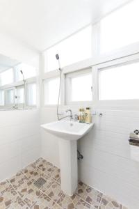 a white bathroom with a sink and a shower at Kory Guesthouse in Seoul