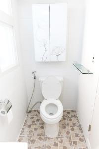 a white bathroom with a toilet and some drawings on the wall at Kory Guesthouse in Seoul