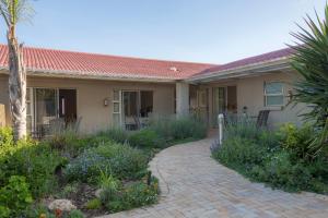 a house with a brick walkway in front of it at Maroela House Guest Accommodation in Bellville