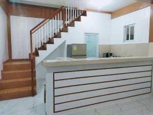 a lobby with a counter with a staircase at Lia Clarke Transient House in Nasugbu