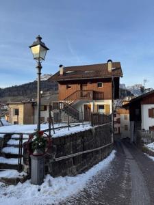 a street light next to a building in the snow at Casa di Lilly in Moena