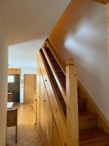 a wooden staircase in a room with a kitchen at Casa di Lilly in Moena