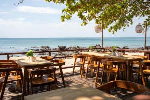a restaurant with tables and chairs on the beach at Relax Bay Beach Resort in Ko Lanta