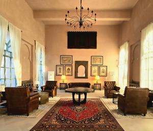 a living room with chairs and a table and a chandelier at Sukoon Gah in Bedla