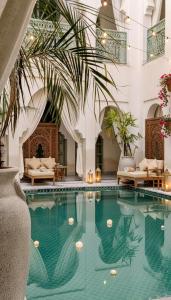 a swimming pool in a hotel with chairs and tables at Sukoon Gah in Bedla +37 photos