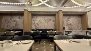 una sala da pranzo con tavoli e sedie e un lampadario di Dragonfly Hotel - The Art Hotel a Mumbai