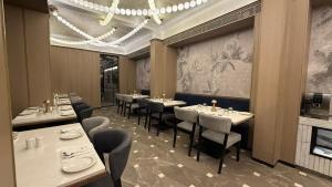 una sala da pranzo con tavoli e sedie e un lampadario di Dragonfly Hotel - The Art Hotel a Mumbai
