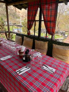 a table with a plaid table cloth and glasses on it at Milkovata Guest House in Koshov