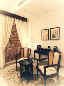 a room with a piano and two chairs and a lamp at Sukoon Gah in Bedla