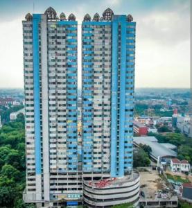 a tall blue and white building in a city at Saladin Guest House in Parungmalela