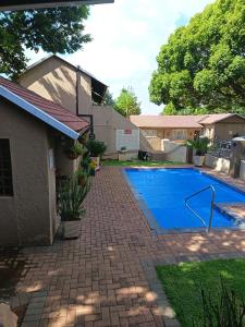 una piscina nel cortile di una casa di African Sky Guest House a Krugersdorp