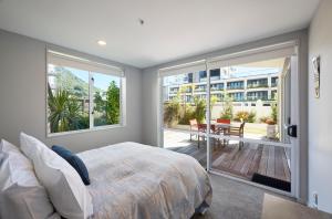 ein Schlafzimmer mit einem Bett und einem großen Fenster in der Unterkunft Beaumont Apartments in Mount Maunganui + 72 Fotos
