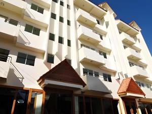 un alto edificio bianco con finestre di Fah Place Hotel a Nan