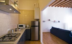 a kitchen with a stove and a refrigerator and a couch at Sarai Apartments in Venice