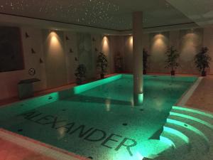 duży basen z zielonym oświetleniem w budynku w obiekcie Willa Alexander Resort & SPA - caloroczny BASEN kryty, szybkie Wifi! w mieście Mielno