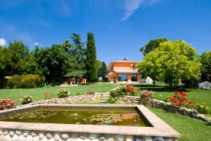 a garden with a pond in front of a house at Bellafiora Affittacamere in Osimo