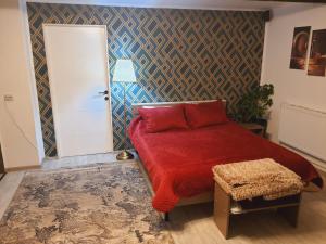 a bedroom with a red bed with a red blanket at Liliana Home in Bucharest