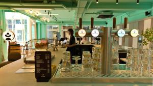 een winkel met een toonbank waarop glazen vazen staan. bij De Lola Podshotel in Den Haag