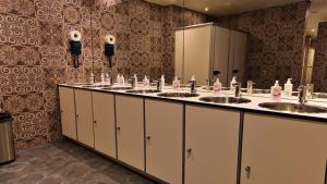 een badkamer met 3 wastafels en 2 spiegels bij De Lola Podshotel in Den Haag +43 foto's