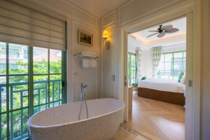 un bagno con vasca in una camera con un letto di Green Villas Tropical Phú Quốc a Phu Quoc