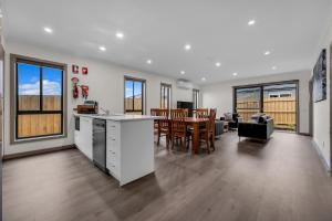 a kitchen and living room with a table and chairs at IK homes in Clyde North