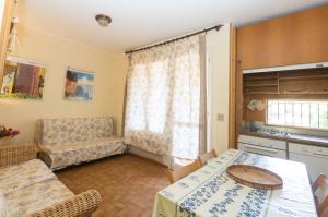 a kitchen and living room with a table and a couch at Capo d'Arco - Goelba in Rio Marina