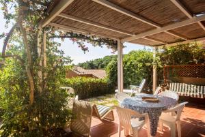 a patio with a table and chairs and a pergola at Capo d'Arco - Goelba in Rio Marina