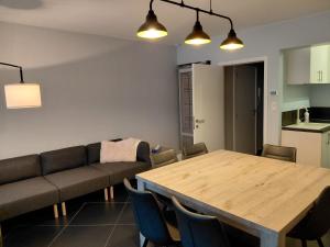 a living room with a wooden table and chairs at App ZeeVorm Nieuw in De Panne +6 photos