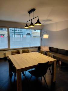 a living room with a wooden table and a couch at App ZeeVorm Nieuw in De Panne