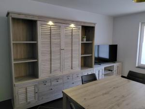 a large wooden cabinet with a television and a table at App ZeeVorm Nieuw in De Panne