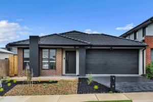 a brick house with a garage at IK homes in Clyde North