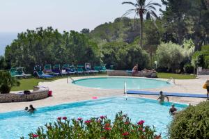 a large swimming pool with people in the water at Capo d'Arco - Goelba in Rio Marina +11 photos