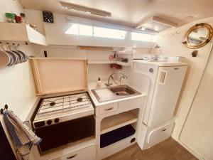 a small kitchen with a sink and a stove at Bateau Péniche à quai 6 couchages in Colombiers